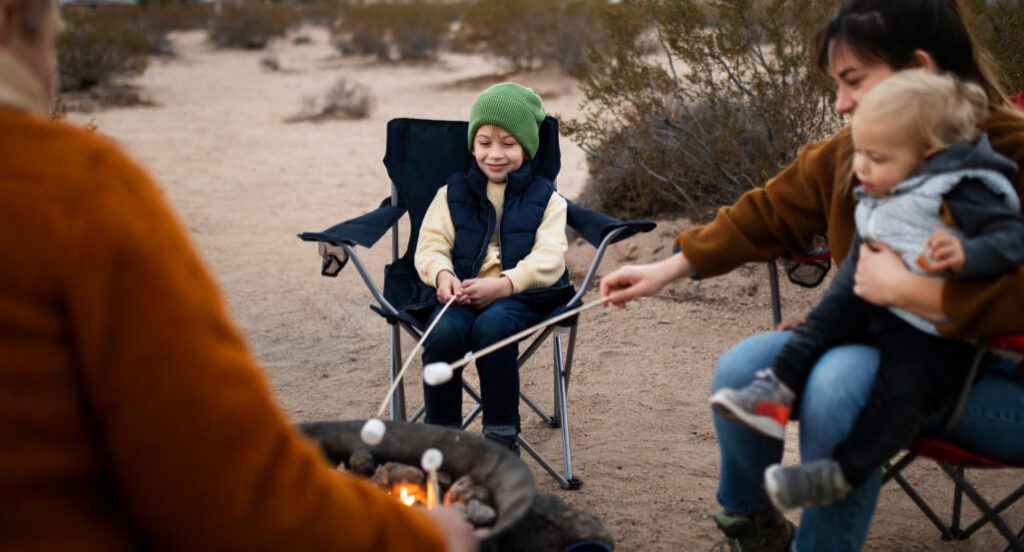 Family gathered around a camp fire, supplied by TCH Gear.